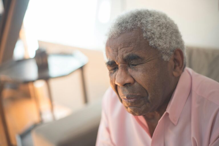 An elderly man with gray hair expresses deep emotion and grief.